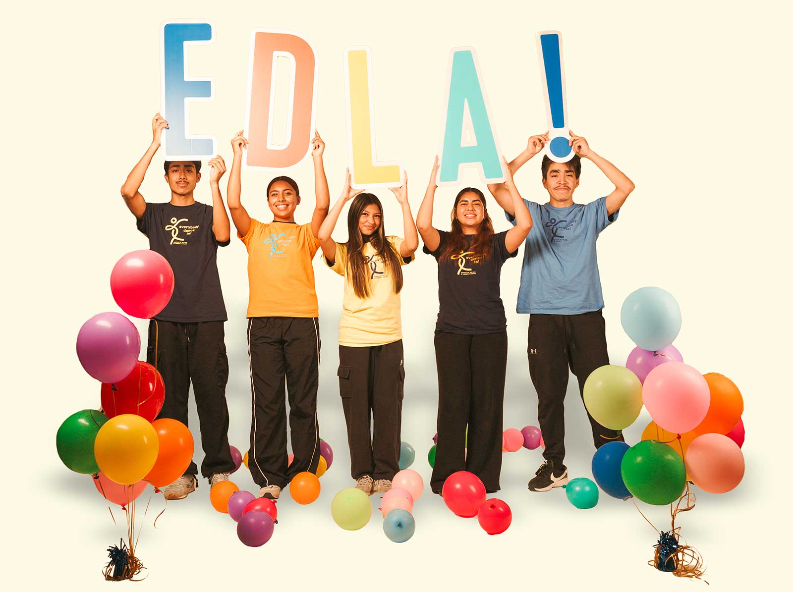 five dance students holding colored EDLA! letters/sign with colorful balloons around them